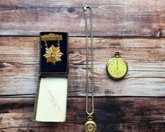 Pocket and pendant watches alongside a boxed fraternal medal—distinctive keepsake pieces for collectors and vintage accessory enthusiasts.