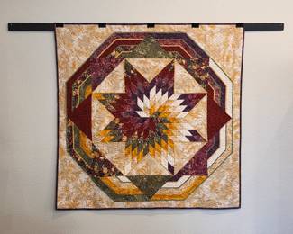 Handmade star medallion wall quilt in burgundy, gold and cream.