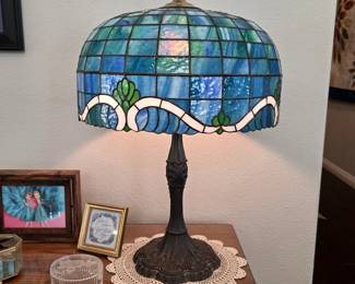 Tiffany-style leaded stained-glass table lamp with blue and green shade.