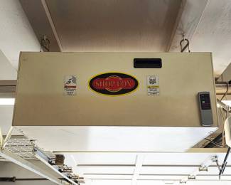 Shop Fox ceiling-hung workshop air filtration system with attached remote control.