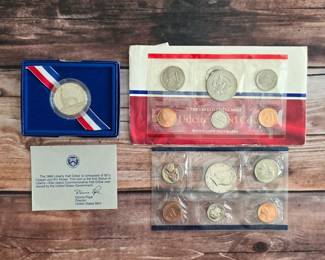 U.S. Mint coin sets and a boxed 1986 Statue of Liberty commemorative half dollar.
