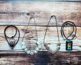 Colorful art glass pendants, a button necklace, and a sculptural disc necklace—distinctive fashion jewelry for shoppers who love something a little different.