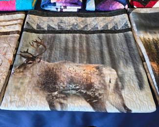 Elk-themed wildlife quilt with a forest scene, pieced triangle border, and flowing machine quilting. A distinctive woodland design from Cathy Farris’s handmade collection.