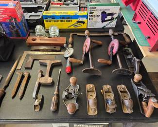 Vintage woodworking hand tools including hand planes, brace drills, chisels and mallets.