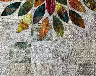 Floral art quilt detail showing dense background quilting beneath the appliqué petals. Feather shapes, tiny circles, and curling stitches create a richly textured surface.
