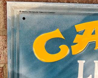A3 - $40. Camel lights metal display sign from 1983. Measures 17.5“ x 21.5. It has a few small scratches, but otherwise in good, vintage shape.
