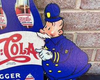 A17 - $85. 1940s Pepsi-Cola Pepsi & Pete Cardboard display counter sign. Measures 22“ x 14.5“. This sign has some creasing on one policeman’s hat. In good vintage shape. Marked 40-20 in the bottom right corner.