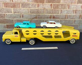 A98 - $160. 1960’s Tonka car carrier #40 with two rider cars. Measures measures 27.25” long.