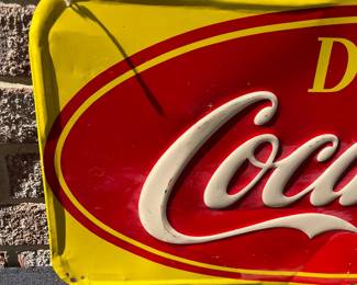 A40 - $325. 1950s Canadian red and yellow Coca-Cola sign. Measures 29.5” x by 12.25”. Some bent and creased metal.