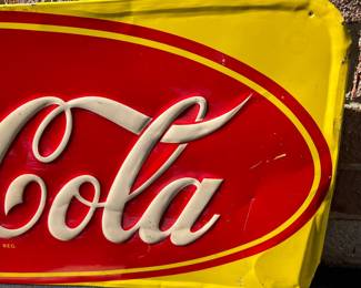 A40 - $325. 1950s Canadian red and yellow Coca-Cola sign. Measures 29.5” x by 12.25”. Some bent and creased metal.