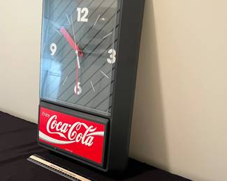 A133 - $30. 1989. Enjoy Coca-Cola wall clock. Measures 13" x 21.5" tall. Needs battery. Face has some scuffs.