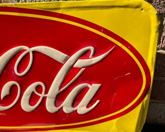 A40 - $325. 1950s Canadian red and yellow Coca-Cola sign. Measures 29.5” x by 12.25”. Some bent and creased metal.