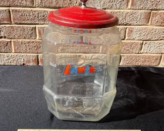 A79 - $80. Red topped Lance glass jar. Measures 12.5” tall. had some rubbed off paint and scratches on the lid.
