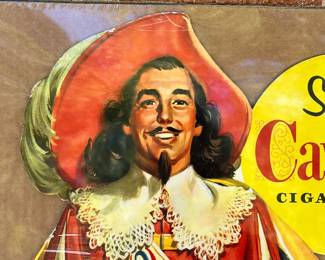 A6 - $80. Cavalier Cigarettes, die-cut counter display sign. Made in 1952. Measures 28 inches tall. Slight bending and creases on the hat and boot otherwise in great, vintage shape.