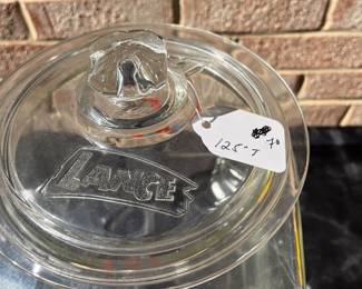 A78 - $70. Lance glass jar. Detailed Lance name top. Measures 12.5" tall. Has some small chipping on the top rim.