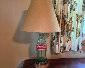 A194 - $30. Coca-Cola Glass Bottle Table Lamp. Measures 28" tall. Shade is in good condition.