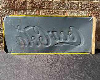 A40 - $325. 1950s Canadian red and yellow Coca-Cola sign. Measures 29.5” x by 12.25”. Some bent and creased metal.