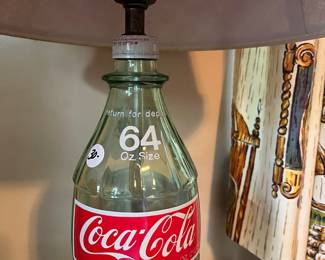 A194 - $30. Coca-Cola Glass Bottle Table Lamp. Measures 28" tall. Shade is in good condition.