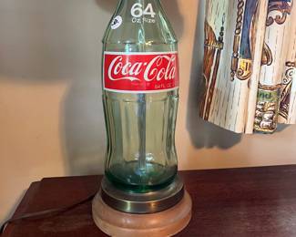 A194 - $30. Coca-Cola Glass Bottle Table Lamp. Measures 28" tall. Shade is in good condition.