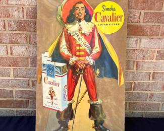A6 - $80. Cavalier Cigarettes, die-cut counter display sign. Made in 1952. Measures 28 inches tall. Slight bending and creases on the hat and boot otherwise in great, vintage shape.