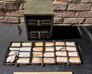 A86 - $150. Eight drawer metal pharmacy cabinet with labels. (Missing one knob) measures 6.5” x 6.5”x 8.5”.