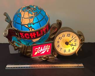 A146 - $115. 1976 Schlitz, beer lighted motion globe and clock. Show signs of age. Globe lights and rotates but clock is not working. Measures 14" x 9.5" tall..