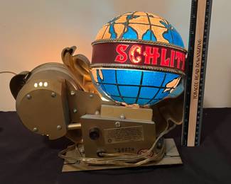 A146 - $115. 1976 Schlitz, beer lighted motion globe and clock. Show signs of age. Globe lights and rotates but clock is not working. Measures 14" x 9.5" tall..