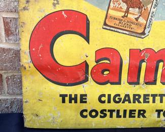 A2 - $225. 1950s Camel Cigarettes counter display die-cut. Measures 33" tall. In fragile condition. Has rips and scrapes throughout. Slightly bowed at the bottom.
