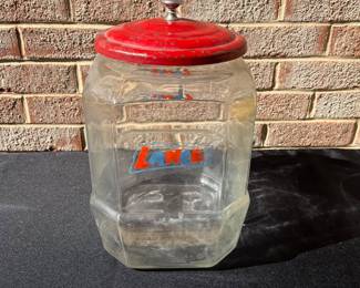 A79 - $80. Red topped Lance glass jar. Measures 12.5” tall. had some rubbed off paint and scratches on the lid.