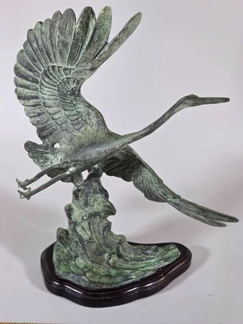 Toyo cast bronze sculpture of a crane or heron in flight taking off from stylized waves
