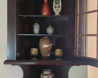 -style corner wall cabinet with glass door, various pottery and porcelain decor