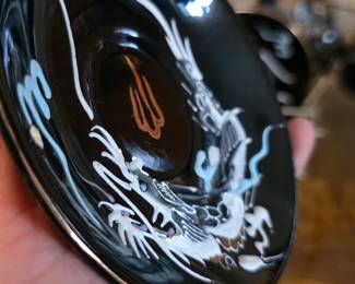 ... with raised hand-painted dragon motifs