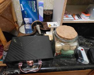 Makeup, jar of soap, water pik, toothbrush and soap holders, hand mirror
