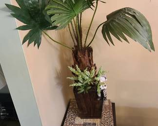 artificial fan palm (such as a Chinese Fan Palm, Livistona chinensis) placed in a decorative brown planter