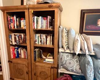 A pair of primitive pine bookcases filled with books