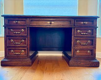 American Drew solid oak 8-drawer desk with glass protector. Measurements: W - 58" / D - 28.5" / H - 31"