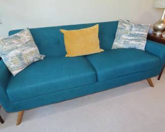 Turquoise/teal colored fabric sofa.