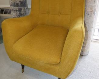 Yellow armchair with deep buttoned back rest.
