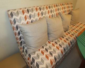 Long padded pew style bench seat.