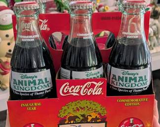 Vintage six-pack of Coca-Cola bottles in original cardboard carrier celebrating the inaugural year of Disney's Animal Kingdom, circa 1998.