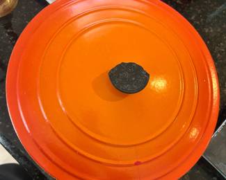 Orange lidded Dutch oven or casserole pot with black knob.