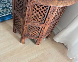 Carved wooden folding screen with geometric lattice panels.