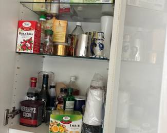 Pantry assortment of canned goods, condiments, jars, and kitchen supplies.