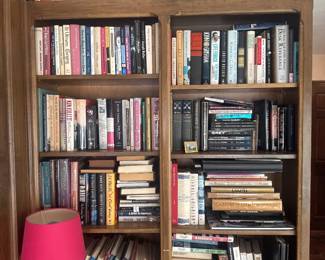 Wood bookcase filled with books in assorted subjects and sizes.