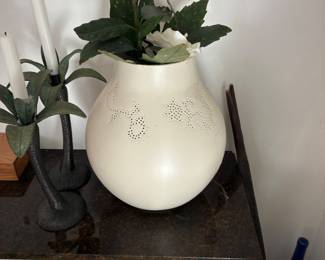 Large cream-colored decorative vase with floral arrangement.