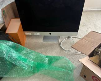 Apple iMac desktop computer with keyboard and desk accessories.