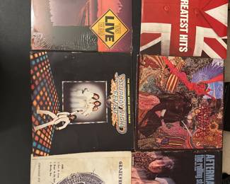 Assorted classic rock vinyl records with illustrated album jackets, including Jethro Tull.