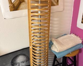 Tall wooden CD storage rack beside assorted household items.
