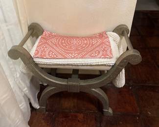 Wooden bench with curved arms and red-and-white patterned upholstery.