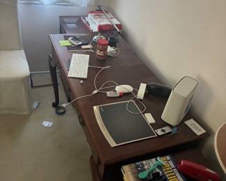 Wood desk with assorted office accessories and electronics.
